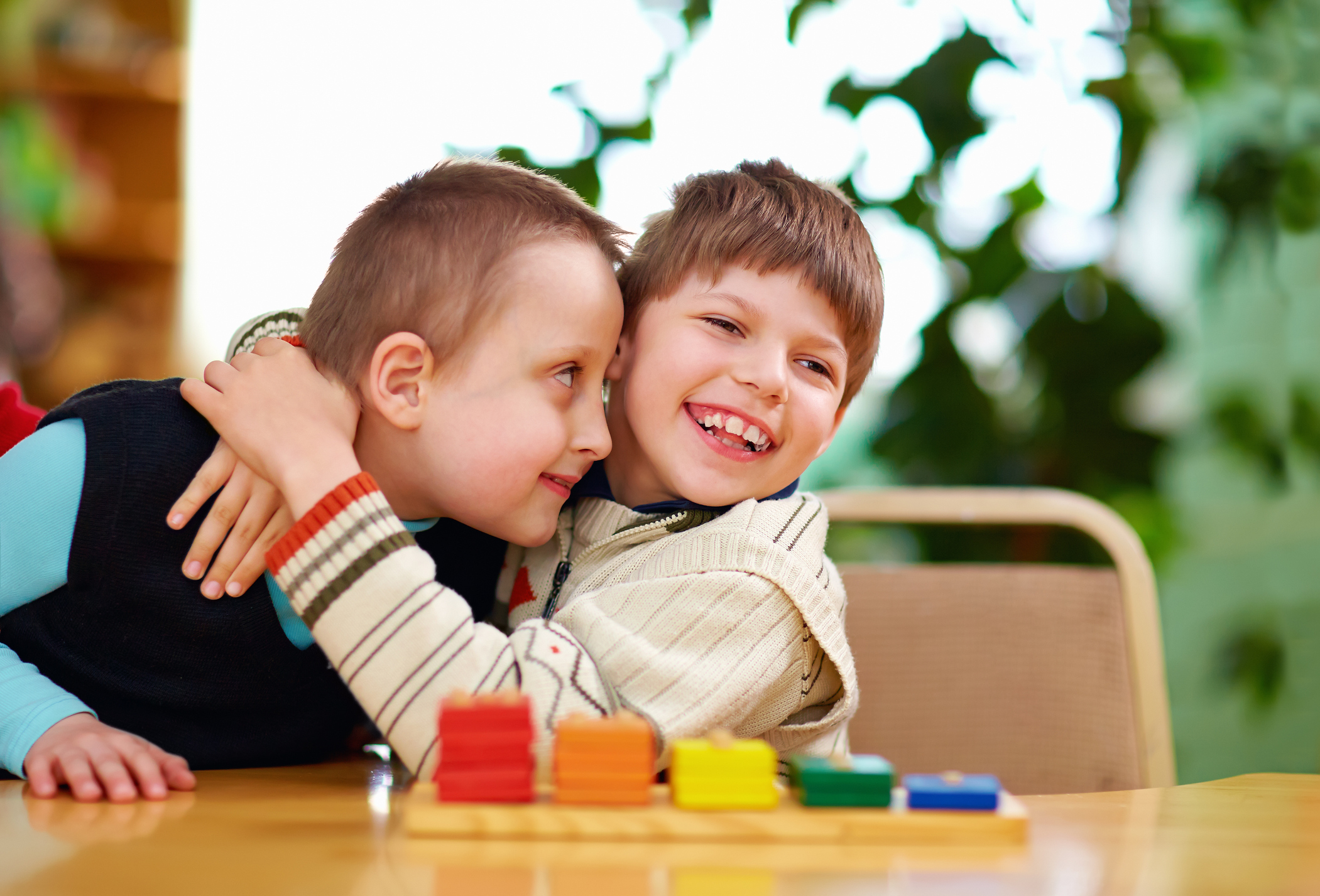 Two disabled boys happily hugging and playing together